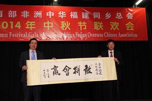 福建省人民政府侨务办公室副主任林泽春(右)赠与南部非洲中华福建同乡总会中秋礼物。