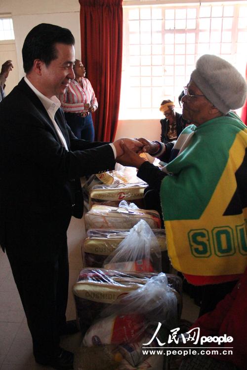 南部非洲中华福建同乡总会会长杨天峙在向自由州省贫困地区民众颁发生活用品。(依拉 摄)